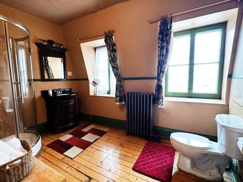 a bathroom with a toilet and a window and a radiator at B&B Au Petit Roi in Quebec City