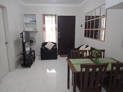 un soggiorno con tavolo, sedie e divano di Cozy9-14 2BR at Mandaue City a Mandaue