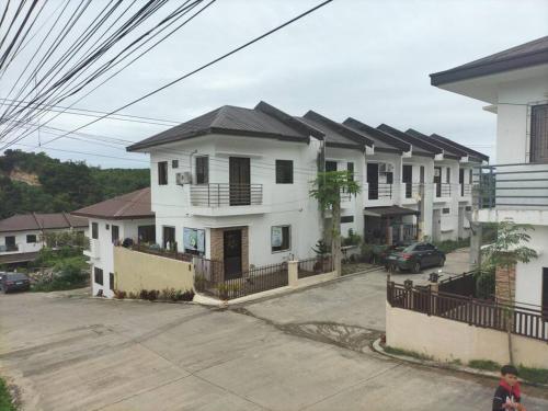 una fila de casas blancas con un estacionamiento en Cozy9-14 2BR at Mandaue City en Mandaue City