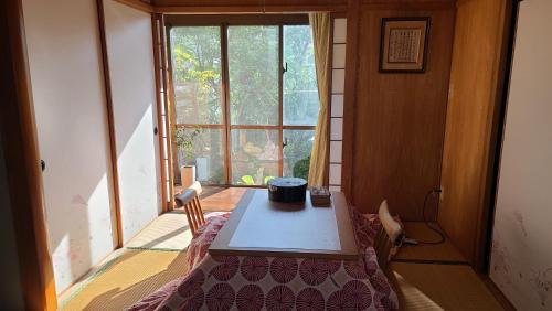 a table in a room with a large window at Haruka 和室 in Naha