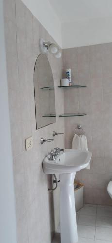 uma casa de banho branca com um lavatório e um espelho em APART IMPERIO 1 em Río Cuarto