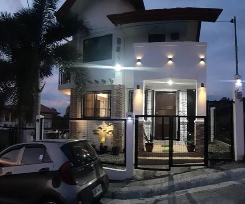 a white house with a car parked in front of it at A sea view 3 bedroom beach vacation home in Camudmud