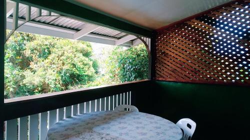 a balcony with a table and a large window at Shalom Mission Home in Mount Hagen