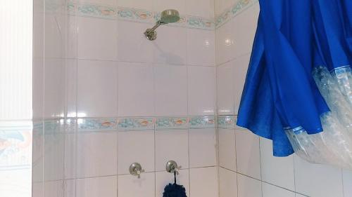 a bathroom with a shower with a blue curtain at Shalom Mission Home in Mount Hagen