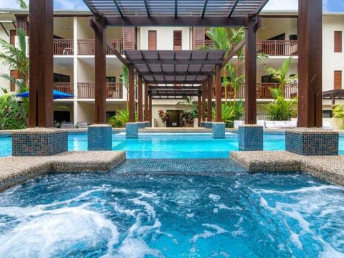 a swimming pool in front of a building at Charming 1 bedroom Apt - Close to Town & Beach in Port Douglas