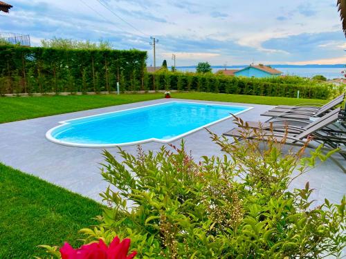 a swimming pool in a yard with chairs around it at LHV Garda Lake - Private POOL and SPA in Bardolino