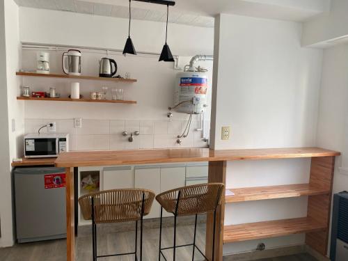 cocina con encimera y 2 sillas en una habitación en Mar del Plata Guemes Centro en Mar del Plata