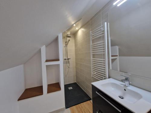 ein weißes Bad mit einem Waschbecken und einer Dusche in der Unterkunft Premium holiday home with living comfort at the highest level, Ploumilliau in Ploumilliau