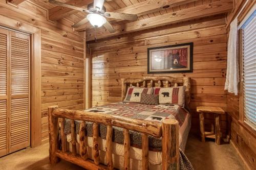 ein Schlafzimmer mit einem Bett in einem Blockhaus in der Unterkunft HEAVENLY HEIGHTS - GREAT LOCATION! CLOSE TO ALL THE ACTION! cabin in Gatlinburg