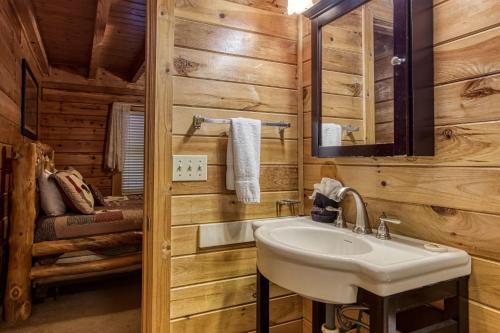 ein Badezimmer mit einem Waschbecken in einer Blockhütte in der Unterkunft HEAVENLY HEIGHTS - GREAT LOCATION! CLOSE TO ALL THE ACTION! cabin in Gatlinburg