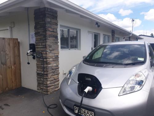 a car parked in front of a house with a brick pillar at Rose Apartments Unit 6 Central Rotorua-Accommodation & Spa in Rotorua