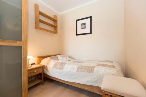 a small bedroom with a bed and a desk at Strandhochhaus 5 in Döse