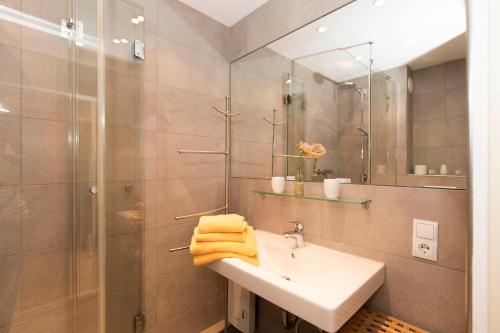 a bathroom with a sink and a shower and a mirror at Strandhochhaus 5 in Döse
