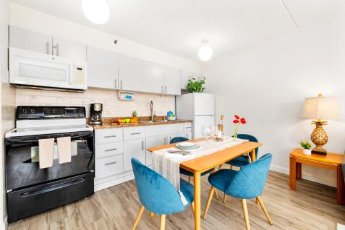 eine Küche mit einem Holztisch und blauen Stühlen in der Unterkunft Charming Condo Steps from Waikiki Beach with Parking! in Honolulu