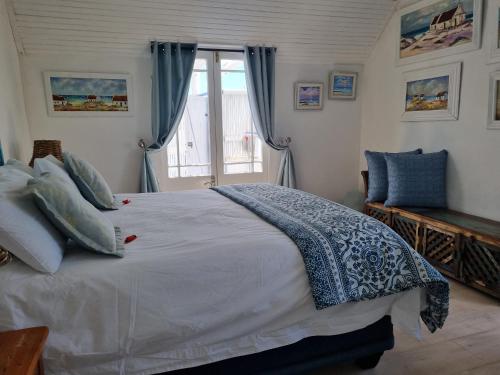 - une chambre avec un grand lit et une fenêtre dans l'établissement Mosselbank Beach Retreat 3, à Paternoster