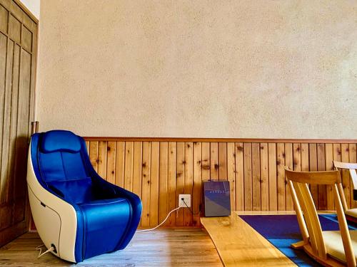 a blue and white chair sitting in a room at Kunugi Relaxation with 4 modern rooms in Hakuba