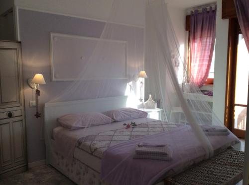 a bedroom with a white bed with a canopy at I Citri in Taranto