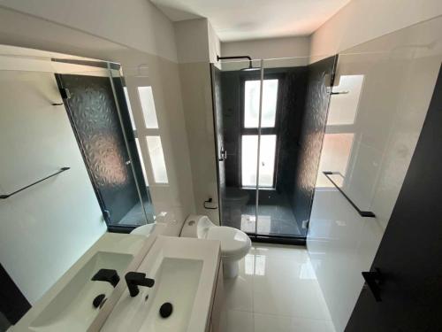 a white bathroom with a sink and a toilet at La Foret 2 dormitorios in Santa Cruz de la Sierra
