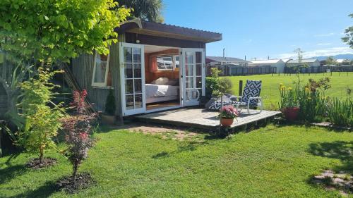 ein winziges Haus mit einer Veranda im Hof in der Unterkunft Delightful 1 bedroom tiny house, with retro Poptop in Westport