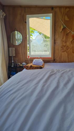 sypialnia z łóżkiem i oknem w obiekcie Delightful 1 bedroom tiny house, with retro Poptop w mieście Westport