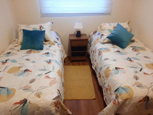 dos camas sentadas una al lado de la otra en un dormitorio en Acogedora casa en Castro, en Castro