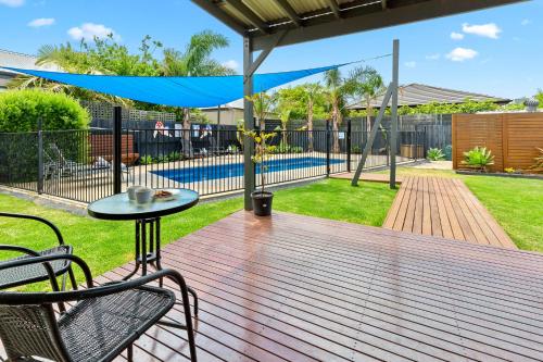 a deck with a table and chairs and a pool at A Rye Retreat - An Entertainers Delight in Rye