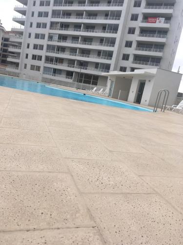 a large building with a swimming pool in front of a building at DEPARTAMENTO EN LA SERENA A PASOS DE LA PLAYA in La Serena