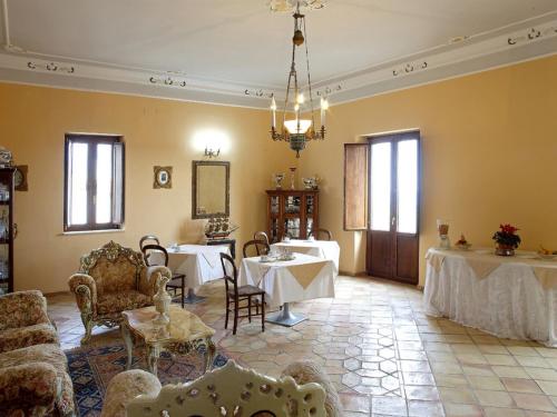 een woonkamer met 2 tafels en stoelen in een kamer bij Palazzo Madeo - Residenza d'Epoca in Crosia