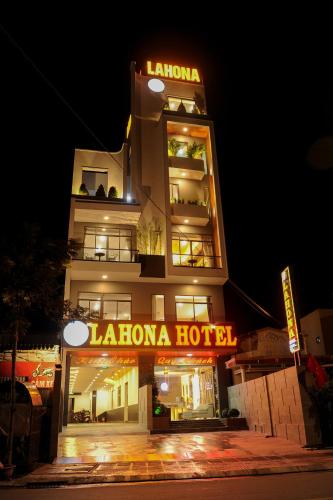 a hotel with a neon sign in front of it at LAHONA HOTEL in La Gi