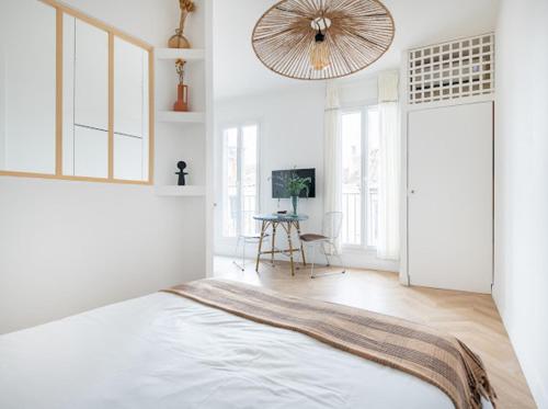 - une chambre blanche avec un lit et un ventilateur dans l'établissement Nau, à Marseille