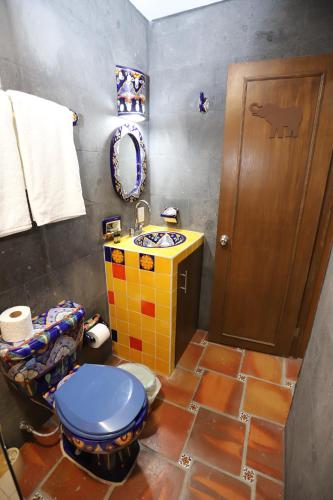 a bathroom with a blue toilet and a sink at Hotel Boutique Casa Elefante in Guadalajara