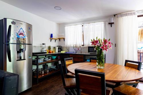 a kitchen with a wooden table and a refrigerator at Shark Town Mal Pais in Santa Teresa Beach