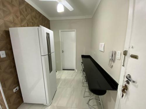 a room with a refrigerator and a table in it at Apartamento frente mar Gonzaga Santos in Santos