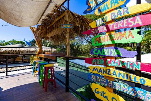 a sign on the deck of a bar with colorful signs at Shark Town Mal Pais in Santa Teresa Beach