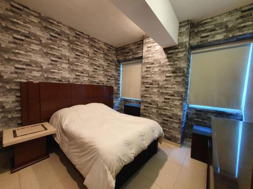 1 dormitorio con cama y pared de ladrillo en Hermoso y amplio departamento 3 rec Polanco, en Ciudad de México