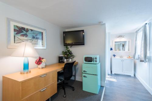 a room with a desk with a computer and a microwave at Gannett Peak Lodge in Pinedale