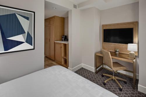 a hotel room with a bed and a desk at Hotel Teatro in Denver