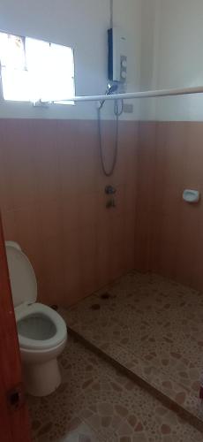 a bathroom with a toilet and a window at Villa Peralta Inn in Donsol