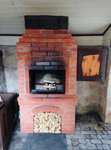 a brick oven with a pile of fire wood at Котедж Chalet Adriana in Bukovel
