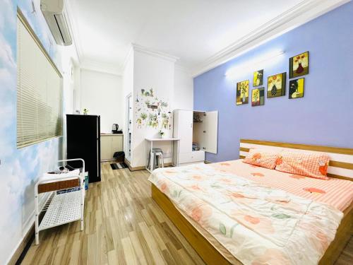 1 dormitorio con 1 cama grande y pared azul en Le Nhim Homestay, en Ho Chi Minh