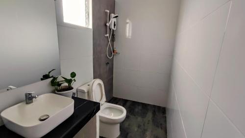 Baño blanco con lavabo y aseo en Cabagnow Seaside Resort en Anda