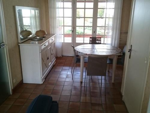- une cuisine avec une table et une table ainsi que quelques fenêtres dans l'établissement Maison F3 à Royan : proche marché, plage et commerces - FR-1-71-58, à Royan