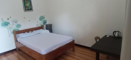 a small bedroom with a bed and a desk at Villa Peralta Inn in Donsol