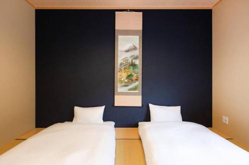 two beds in a room with a blue wall at Kyoto Lanlan Villa in Kyoto