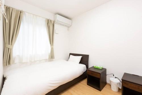 a bedroom with two beds and a window at Kyoto Lanlan Villa in Kyoto