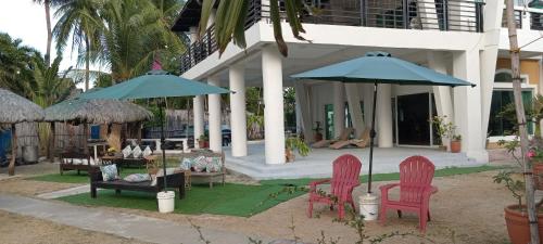 a house with two chairs and a table and an umbrella at North Shores Inn in Currimao