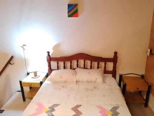 a bedroom with a bed with a wooden head board at DEPARTAMENtO LOFT in Posadas