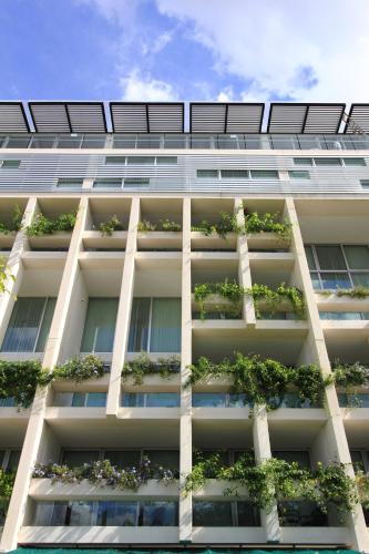 an apartment building with potted plants on the facade at Mesón de la Luna Hotel & Spa in Mérida