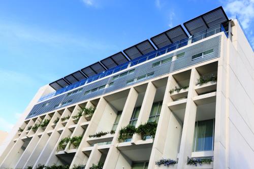 a white building with potted plants on it at Mesón de la Luna Hotel & Spa in Mérida