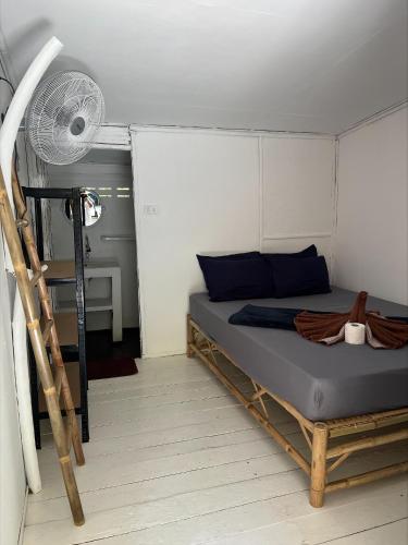 a small bedroom with a bed and a fan at Haad Chao Phao Resort in Haad Chao Phao
